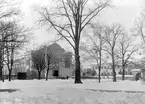 Linköpingsvy som inte nämnvärt förändrats sedan fotograf Didrik von Essen frös den vintern 1902. I blickfånget låg då som nu läroverkets unika gymnastikhus, uppfört 1880-81 efter ritningar av linköpingsingenjören Rudolf Ström med viss bearbetning av den från Stockholm verksamme arkitekten Axel Fredrik Nyström. Resultatet blev en stolt byggnad i en slags tegelrenässans med höga fönster och rik putsdekor. Över portalen ses ett medaljongporträtt av den svenska gymnastikens fader, Pehr Henrik Ling. Till höger skymtar Konsistoriehuset som även det ännu står kvar i oförändrat skick.