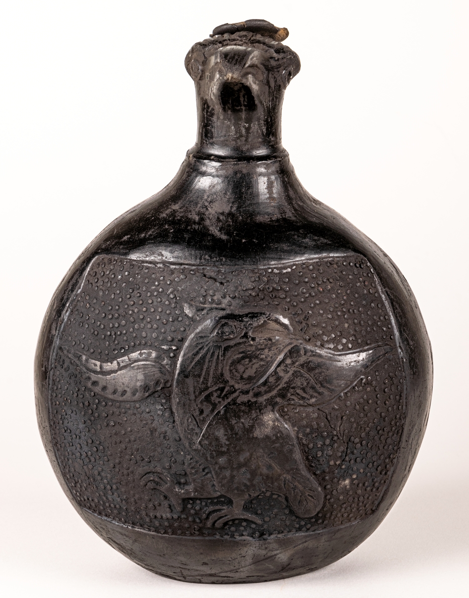 Gravkärl, inca, så kallat svartgods, med fågelhuvud, örn och pelikan.