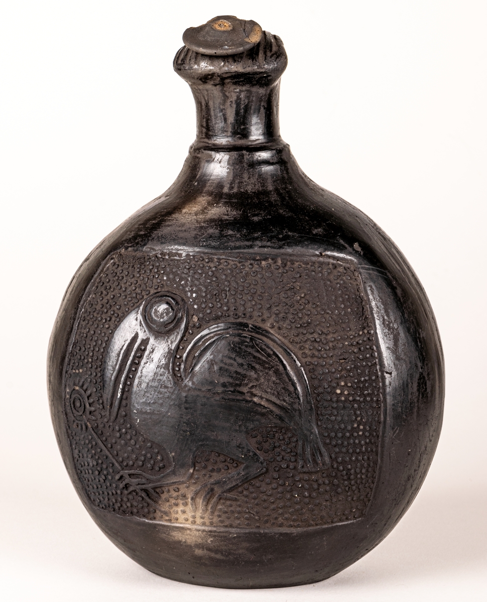 Gravkärl, inca, så kallat svartgods, med fågelhuvud, örn och pelikan.