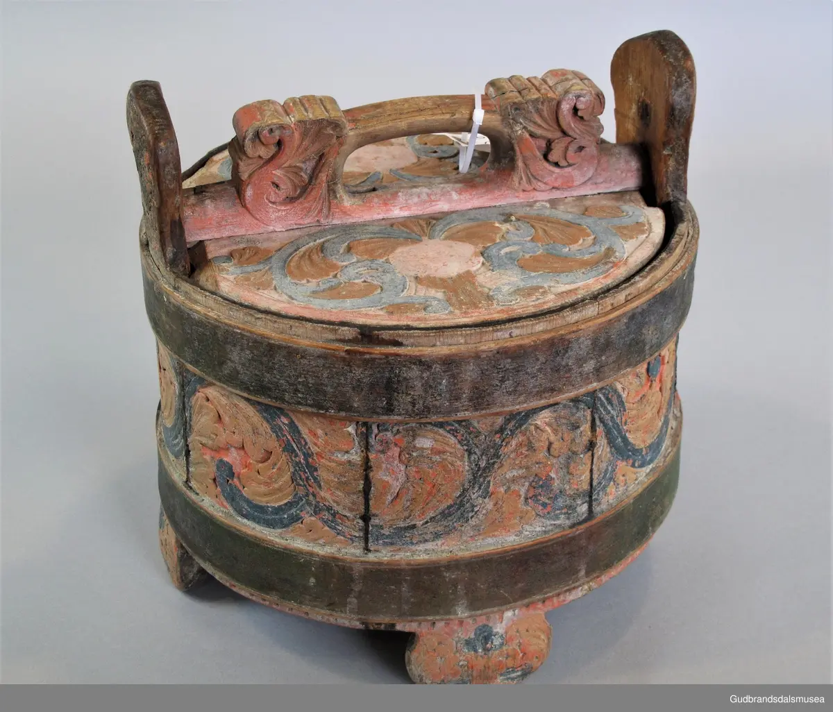 Grøtambar med to ørestaver, lokk med håndtak og to gjorder rundt korpus. Lokket blir festet til ørestavene med tapp i den ene enden av håndtaket og en pinne gjennom et hull i den andre enden. Håndtaket er festet til lokket i en fals. Korpus hviler på tre staver som har utskårne føtter.
Dekor. Malt skurd i rødt gult og blått, fargetrenden seint på 1700-tallet, tidlig 1800-tallet. All maling er svært falmet og slitt. Skurden på korpus og lokk har tydelige stengler med mye bladverk. Lokket har stengler i rocaille med c-former, et stilelement fra rokokkoen.