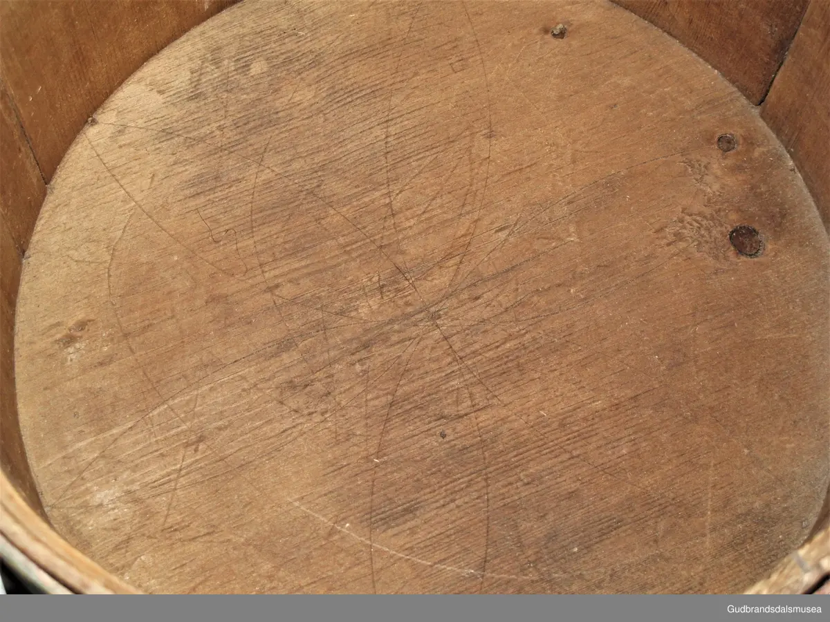 Grøtambar med to ørestaver, lokk med håndtak og to gjorder rundt korpus. Lokket blir festet til ørestavene med tapp i den ene enden av håndtaket og en pinne gjennom et hull i den andre enden. Håndtaket er festet til lokket i en fals. Korpus hviler på tre av stavene som har utskårne føtter.
Lokk og ører har malt skurddekor. Lokket har skurd med palmettmotiv i nyklassisistisk stil. Korpus er rosemalt med en enkel, tydelig ranke med lite utviklet bladverk. Fargebruken på både skurd og rosemalingen er holdt i det seine 1700-tallets, det tidlige 1800-tallets mørkere grønne og gule farger.
I ambarbunnet er det innrisset en seksbladrose.