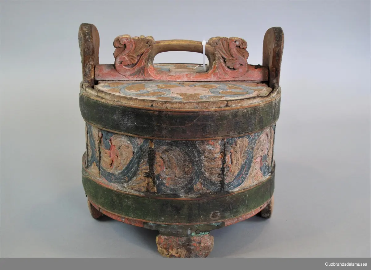 Grøtambar med to ørestaver, lokk med håndtak og to gjorder rundt korpus. Lokket blir festet til ørestavene med tapp i den ene enden av håndtaket og en pinne gjennom et hull i den andre enden. Håndtaket er festet til lokket i en fals. Korpus hviler på tre staver som har utskårne føtter.
Dekor. Malt skurd i rødt gult og blått, fargetrenden seint på 1700-tallet, tidlig 1800-tallet. All maling er svært falmet og slitt. Skurden på korpus og lokk har tydelige stengler med mye bladverk. Lokket har stengler i rocaille med c-former, et stilelement fra rokokkoen.