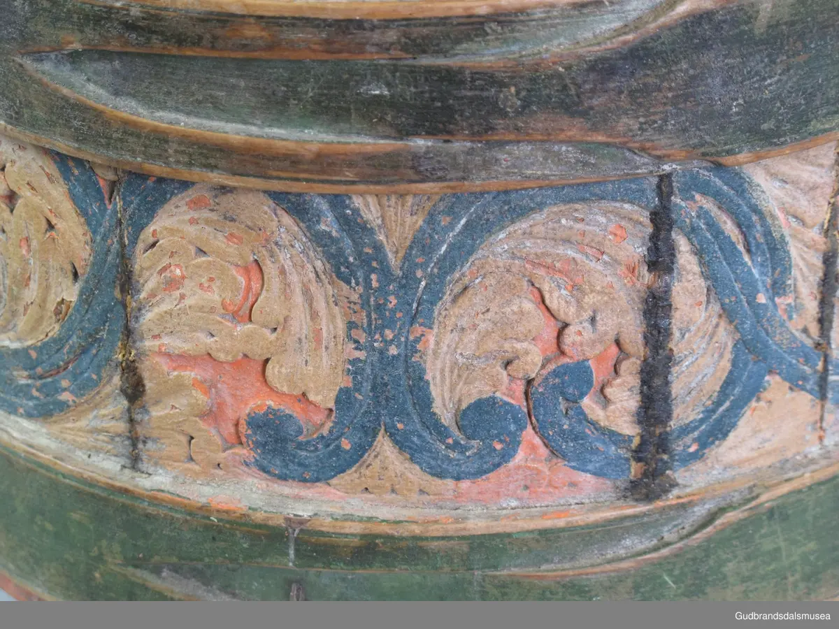 Grøtambar med to ørestaver, lokk med håndtak og to gjorder rundt korpus. Lokket blir festet til ørestavene med tapp i den ene enden av håndtaket og en pinne gjennom et hull i den andre enden. Håndtaket er festet til lokket i en fals. Korpus hviler på tre staver som har utskårne føtter.
Dekor. Malt skurd i rødt gult og blått, fargetrenden seint på 1700-tallet, tidlig 1800-tallet. All maling er svært falmet og slitt. Skurden på korpus og lokk har tydelige stengler med mye bladverk. Lokket har stengler i rocaille med c-former, et stilelement fra rokokkoen.