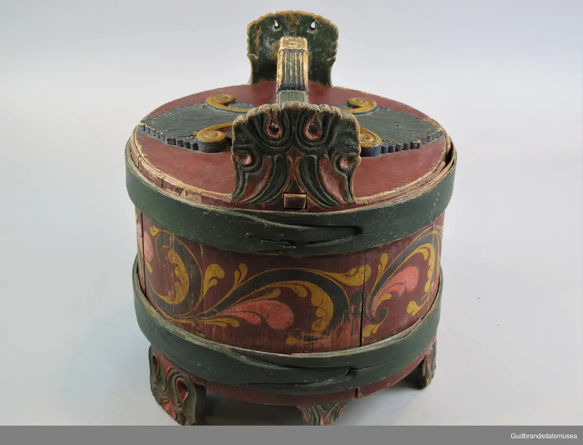 Grøtambar med to ørestaver, lokk med håndtak og to gjorder rundt korpus. Lokket blir festet til ørestavene med tapp i den ene enden av håndtaket og en pinne gjennom et hull i den andre enden. Håndtaket er festet til lokket i en fals. Korpus hviler på tre av stavene som har utskårne føtter.
Lokk og ører har malt skurddekor. Lokket har skurd med palmettmotiv i nyklassisistisk stil. Korpus er rosemalt med en enkel, tydelig ranke med lite utviklet bladverk. Fargebruken på både skurd og rosemalingen er holdt i det seine 1700-tallets, det tidlige 1800-tallets mørkere grønne og gule farger.
I ambarbunnet er det innrisset en seksbladrose.