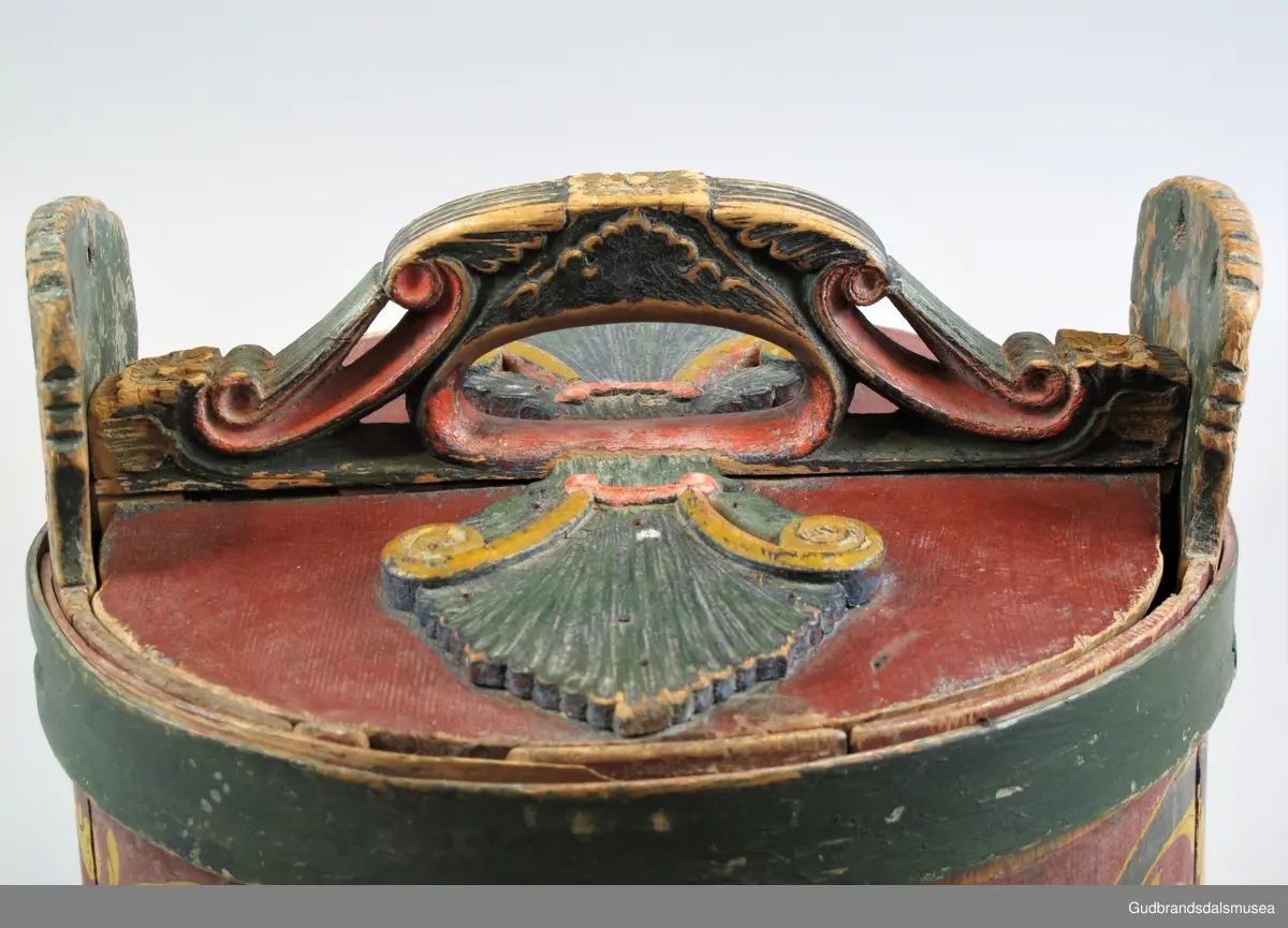 Grøtambar med to ørestaver, lokk med håndtak og to gjorder rundt korpus. Lokket blir festet til ørestavene med tapp i den ene enden av håndtaket og en pinne gjennom et hull i den andre enden. Håndtaket er festet til lokket i en fals. Korpus hviler på tre av stavene som har utskårne føtter.
Lokk og ører har malt skurddekor. Lokket har skurd med palmettmotiv i nyklassisistisk stil. Korpus er rosemalt med en enkel, tydelig ranke med lite utviklet bladverk. Fargebruken på både skurd og rosemalingen er holdt i det seine 1700-tallets, det tidlige 1800-tallets mørkere grønne og gule farger.
I ambarbunnet er det innrisset en seksbladrose.