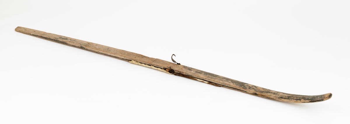 Skiet har ingen stei. Rett avskåret bak. Rygg ca. 38 cm fra tuppen. L skarerand: 201 cm. Finbøy med profilert tupp (skråskjært). Skiet har kun skinn midt under skiet. Mangler såle. Bindingen har bestått av vidje og lærbinding. Baktungt.