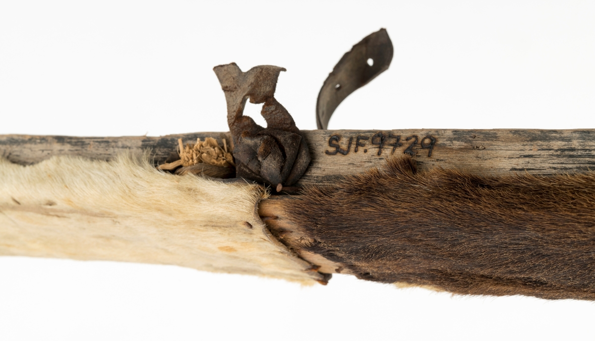 Skiet har ingen stei. Rett avskåret bak. Rygg ca. 38 cm fra tuppen. L skarerand: 201 cm. Finbøy med profilert tupp (skråskjært). Skiet har kun skinn midt under skiet. Mangler såle. Bindingen har bestått av vidje og lærbinding. Baktungt.