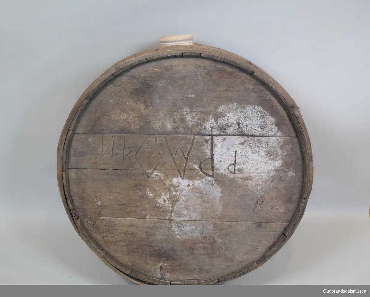 Flaske brukt til transport av flytende melkeprodukter eller annen drikke. Rommer ca. 57 liter. Lagget med korte staver holdt på plass av to 3 cm. brede gjorder. Gjordene  er festet dels med treplugger dels med spiker. To runde sider og åpning med spuns i toppen. Den ene siden er byttet ut med en plate av finèr. Flasken ble båret på ryggen festet til en meis eller som kløv på en hest.