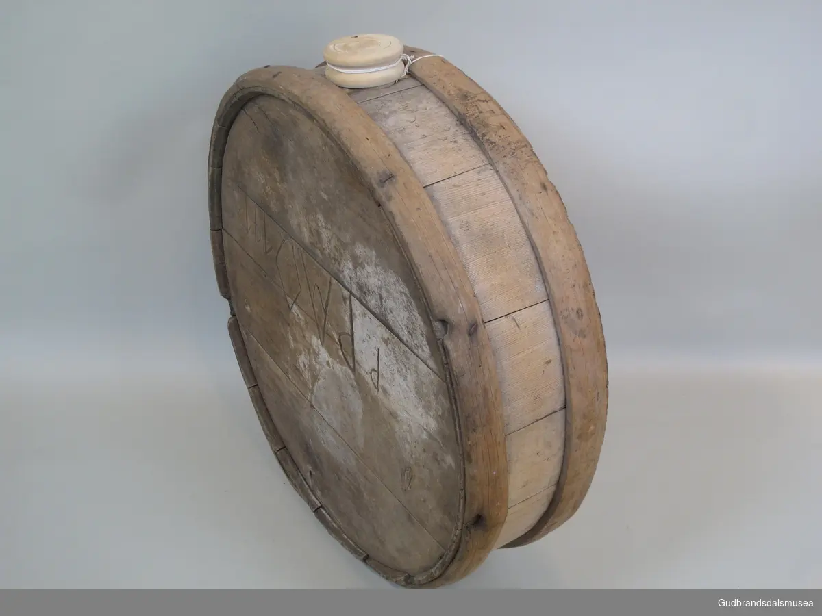 Flaske brukt til transport av flytende melkeprodukter eller annen drikke. Rommer ca. 57 liter. Lagget med korte staver holdt på plass av to 3 cm. brede gjorder. Gjordene  er festet dels med treplugger dels med spiker. To runde sider og åpning med spuns i toppen. Den ene siden er byttet ut med en plate av finèr. Flasken ble båret på ryggen festet til en meis eller som kløv på en hest.
