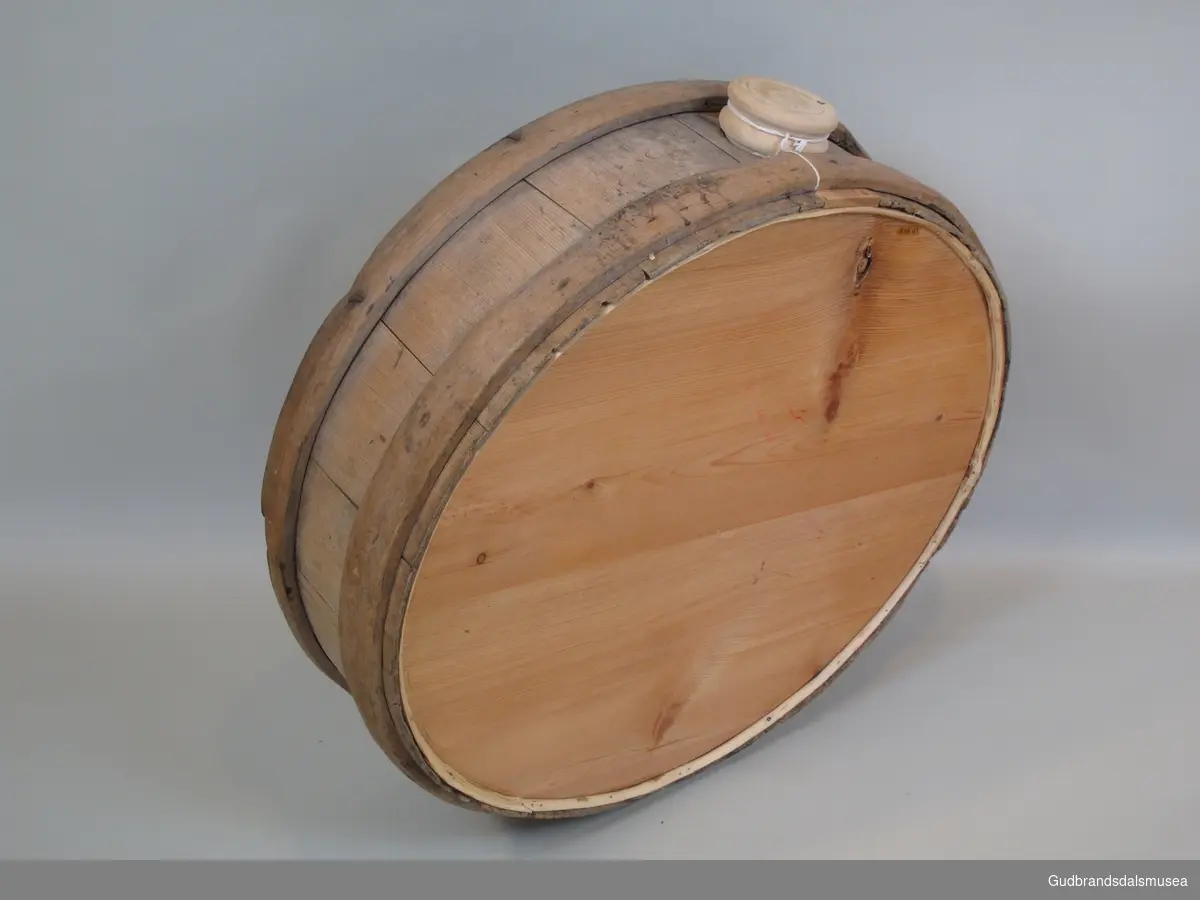 Flaske brukt til transport av flytende melkeprodukter eller annen drikke. Rommer ca. 57 liter. Lagget med korte staver holdt på plass av to 3 cm. brede gjorder. Gjordene  er festet dels med treplugger dels med spiker. To runde sider og åpning med spuns i toppen. Den ene siden er byttet ut med en plate av finèr. Flasken ble båret på ryggen festet til en meis eller som kløv på en hest.