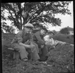 Tre skolpojkar letar efter fynd i jordmassor från den inre vallgraven vid Rumlaborg i Huskvarna sommaren 1935. Fotot togs i samband med arkeologiska undersökningar vid borgen och jordmassorna hade grävst upp från vallgraven föregående vinter och lagts på den inre vallen för att torka.