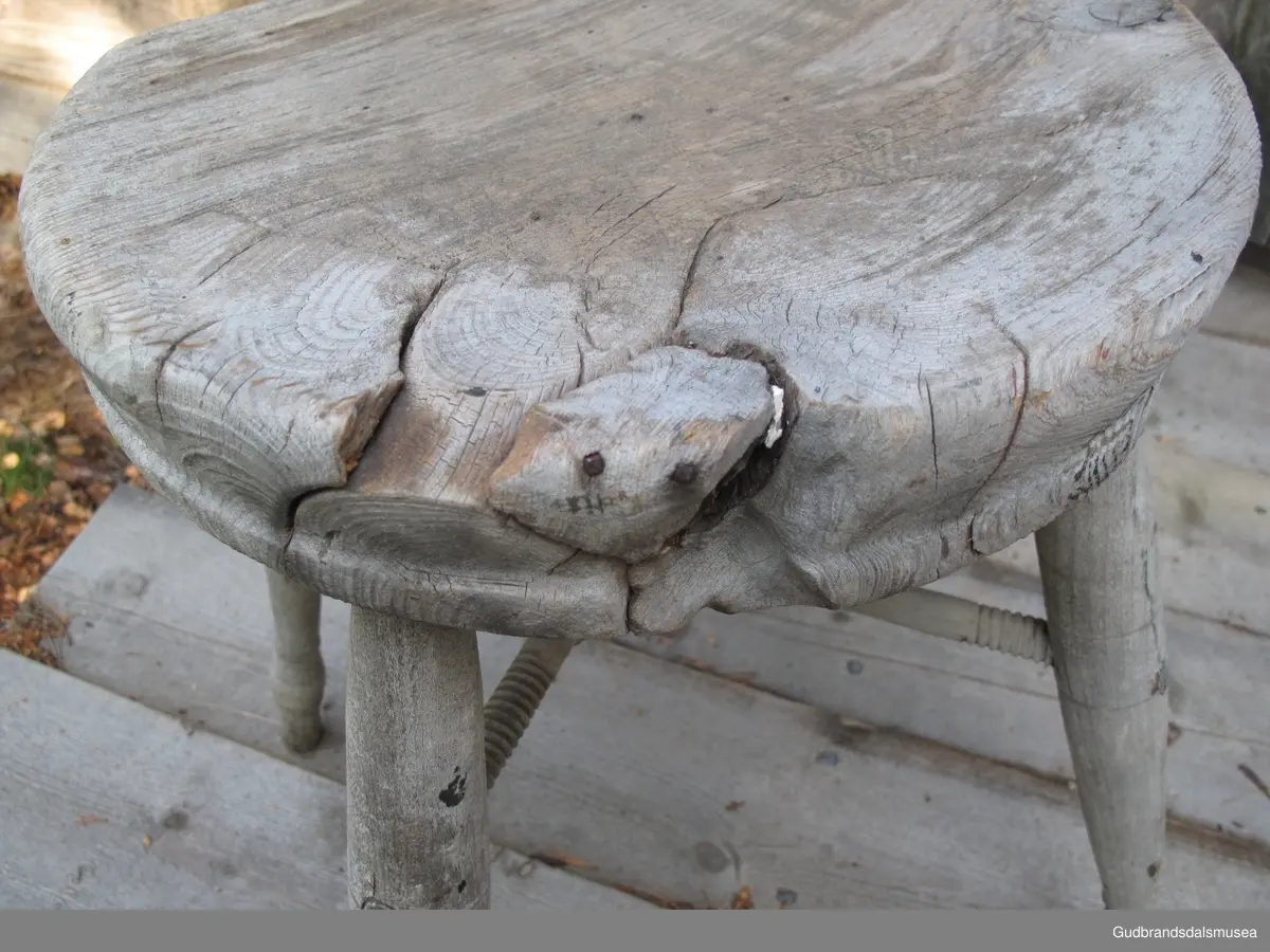 Firbeinet krakk. Beinene er dreid, tappet i stolsetet og i tillegg holdt på plass av to sposser i kors, festet til hverandre med en skrue. Sprossene er festet til beinene med dreid skugang i endene. Treet i setet har sprekker pga. inntørking. Løse trestykker som følge av inntørkingen har blitt spikret fast.