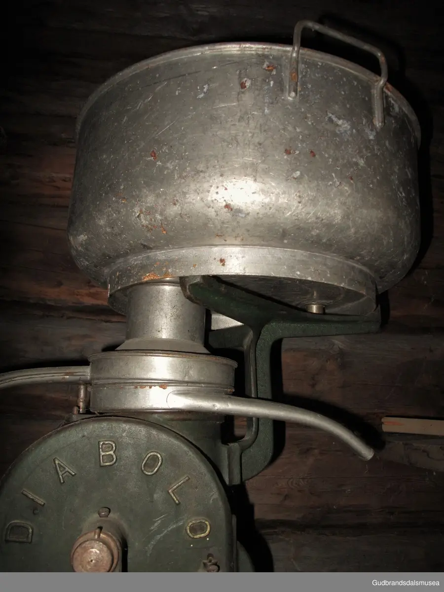 Hånddrevet separator i støpejern med separatorspann med to hanker, fløte- og skummetmelsktud i lettmetall. Montert på en ca. halv meter høy treoppsats med horisontalt brett for plassering av melkebeholder el.l. Sveiv i jern med treinnfattet håndtak. På sveiven står det 60 T. pr. Min. Antakelig er det en bruksveiledning som forteller hvor mange omdreininger man må ha pr. minutt for å få den rette hastigheten.