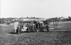 Nio män står framför flygplan FVM S 21 med övningsmärkning vid Upplandsmanövern 1926.