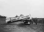 Flygplan Texaco no 13 står på flygfältet på F 3 Malmen vid besök den 20 maj 1931. Militärer runtomkring. I bakgrunden syns flygplan S 6.