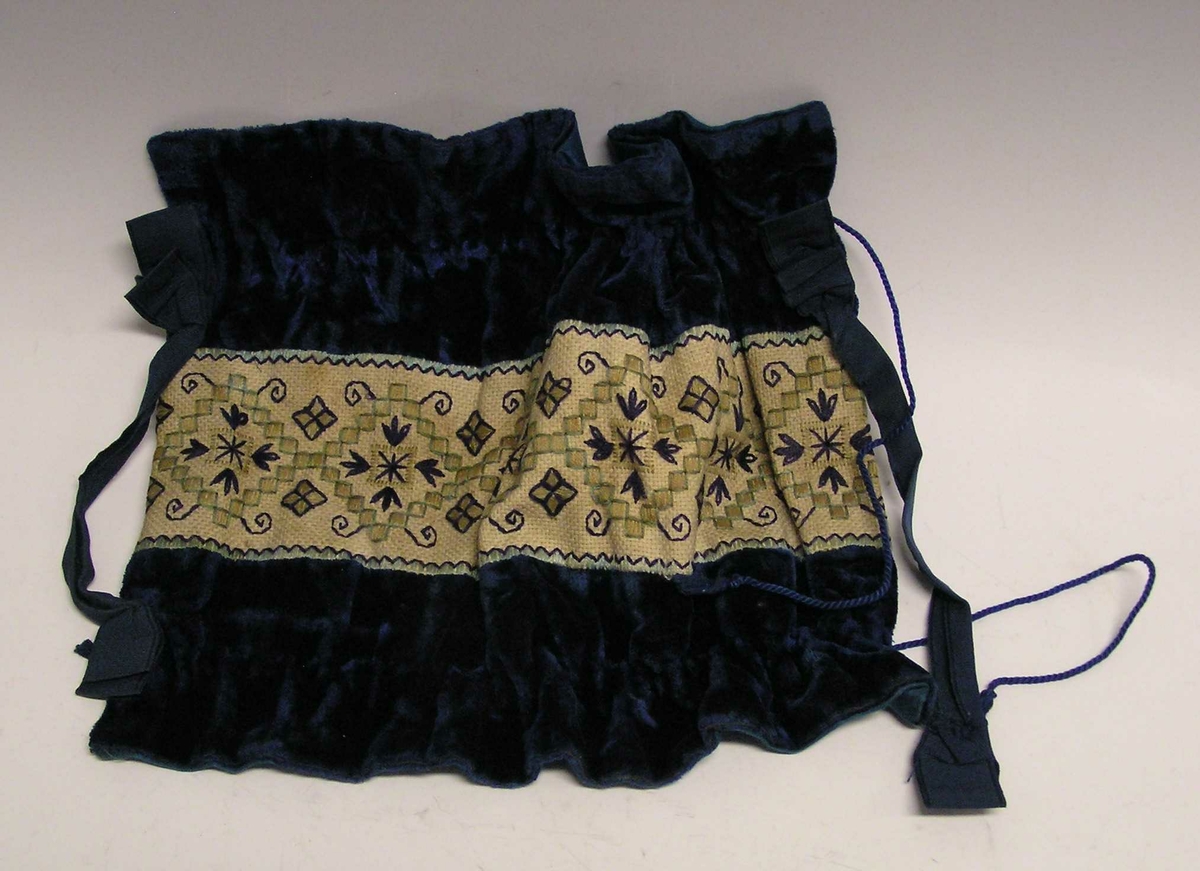 Et stykke med kanvasstoff - midtfelt - med  broderi. Stiliserte blomster.