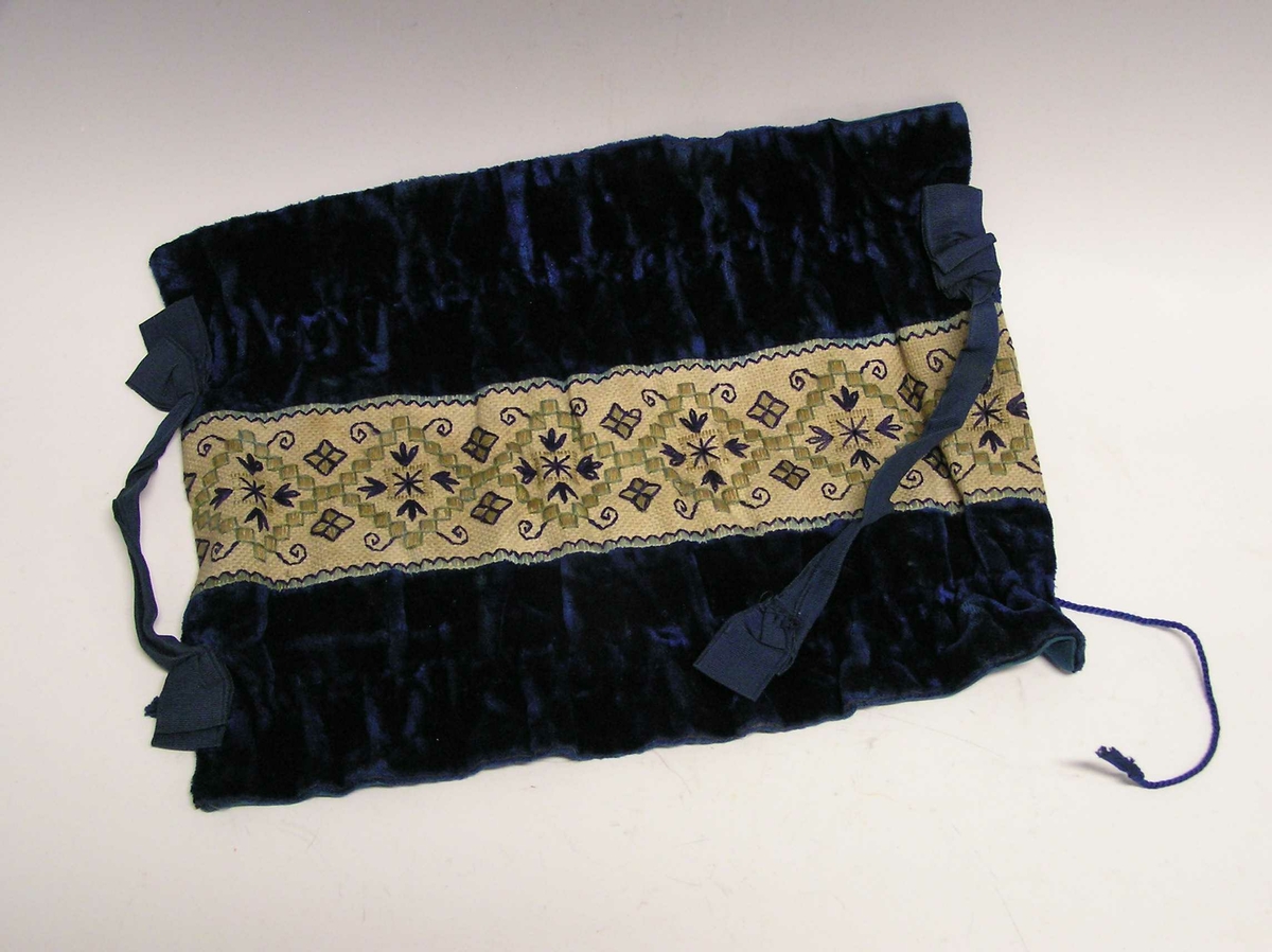 Et stykke med kanvasstoff - midtfelt - med  broderi. Stiliserte blomster.