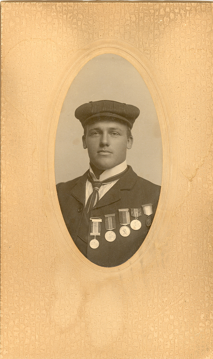 Ovalt brystbilde av Knut G. Helland i Amerika i 1906. Han har fem skimedaljer på brystet.