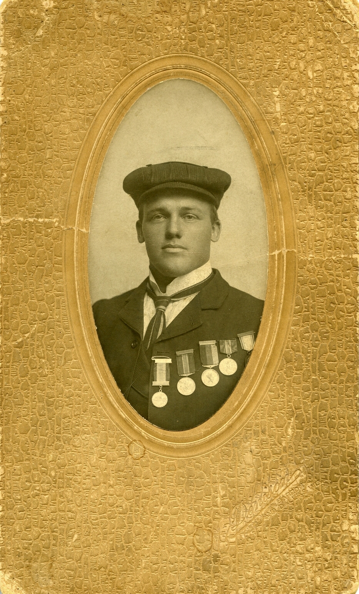 Ovalt brystbilde av Knut G. Helland i Amerika i 1906. Han har fem skimedaljer på brystet.