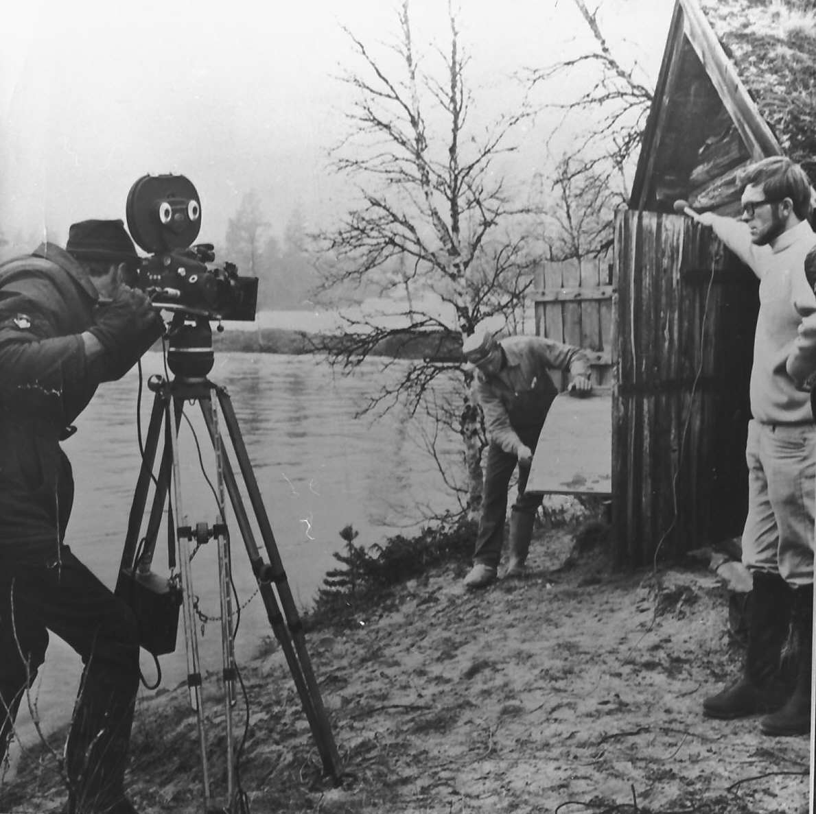 Filmteam intervjuer en mann ved et båtnauster. 