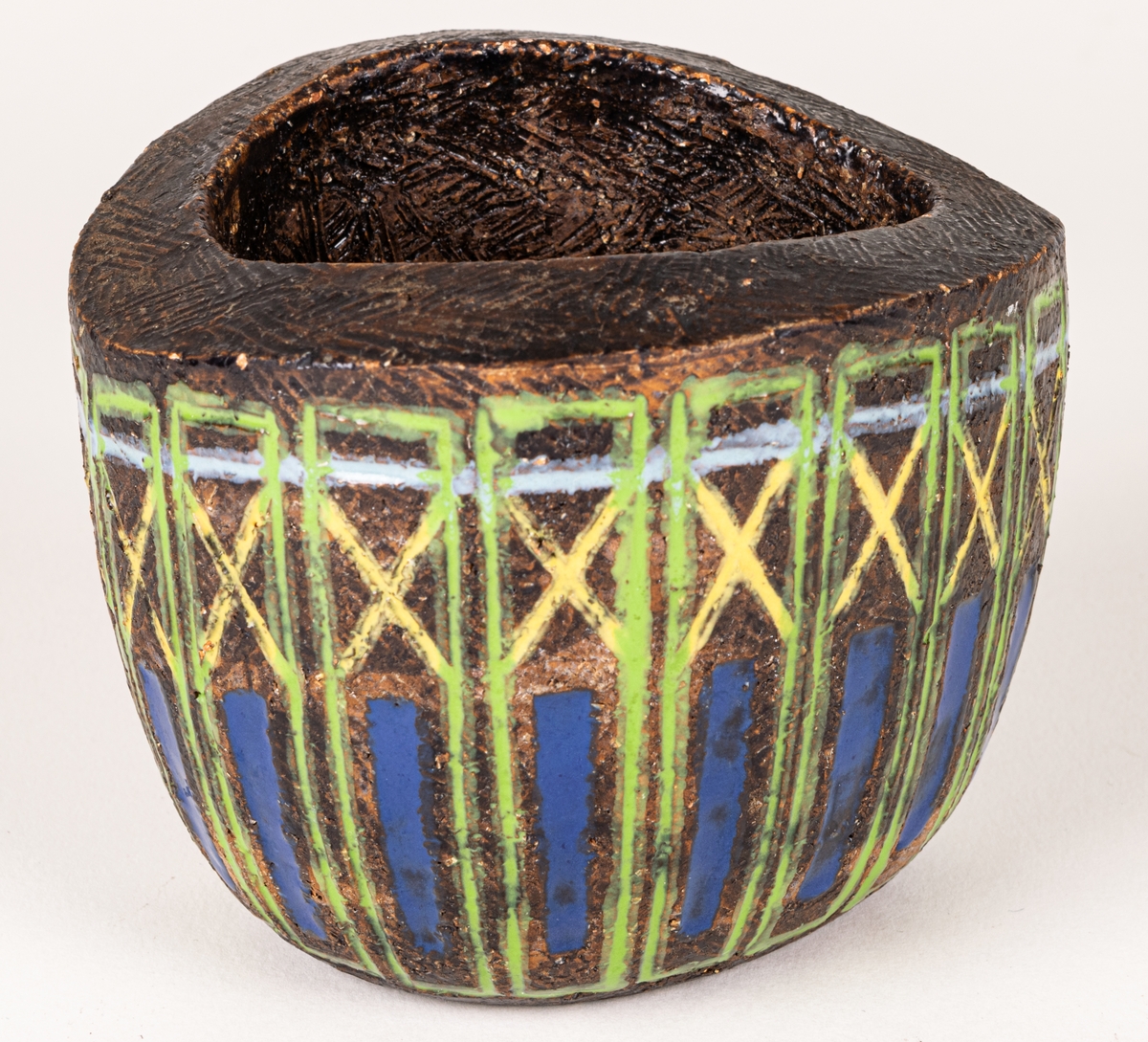 Bägare i svartbrun chamotte med blå, gula och gröna glasyrfyllda ristningar, formgiven av Berit Ternell 1953 hos Bo Fajans.