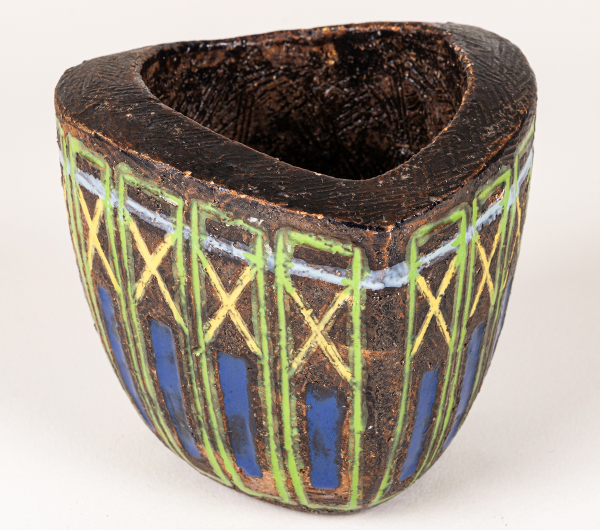 Bägare i svartbrun chamotte med blå, gula och gröna glasyrfyllda ristningar, formgiven av Berit Ternell 1953 hos Bo Fajans.