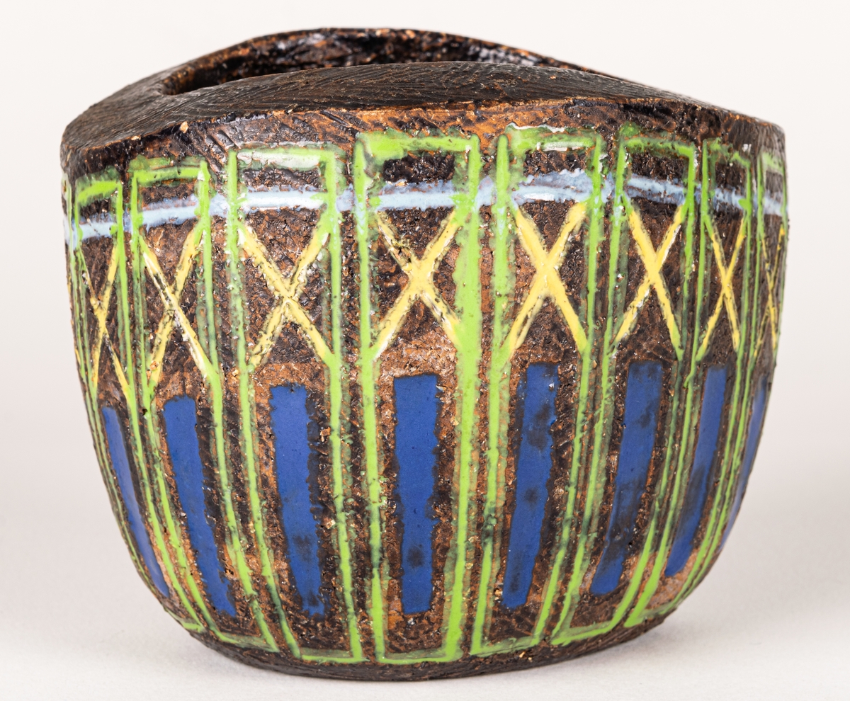 Bägare i svartbrun chamotte med blå, gula och gröna glasyrfyllda ristningar, formgiven av Berit Ternell 1953 hos Bo Fajans.