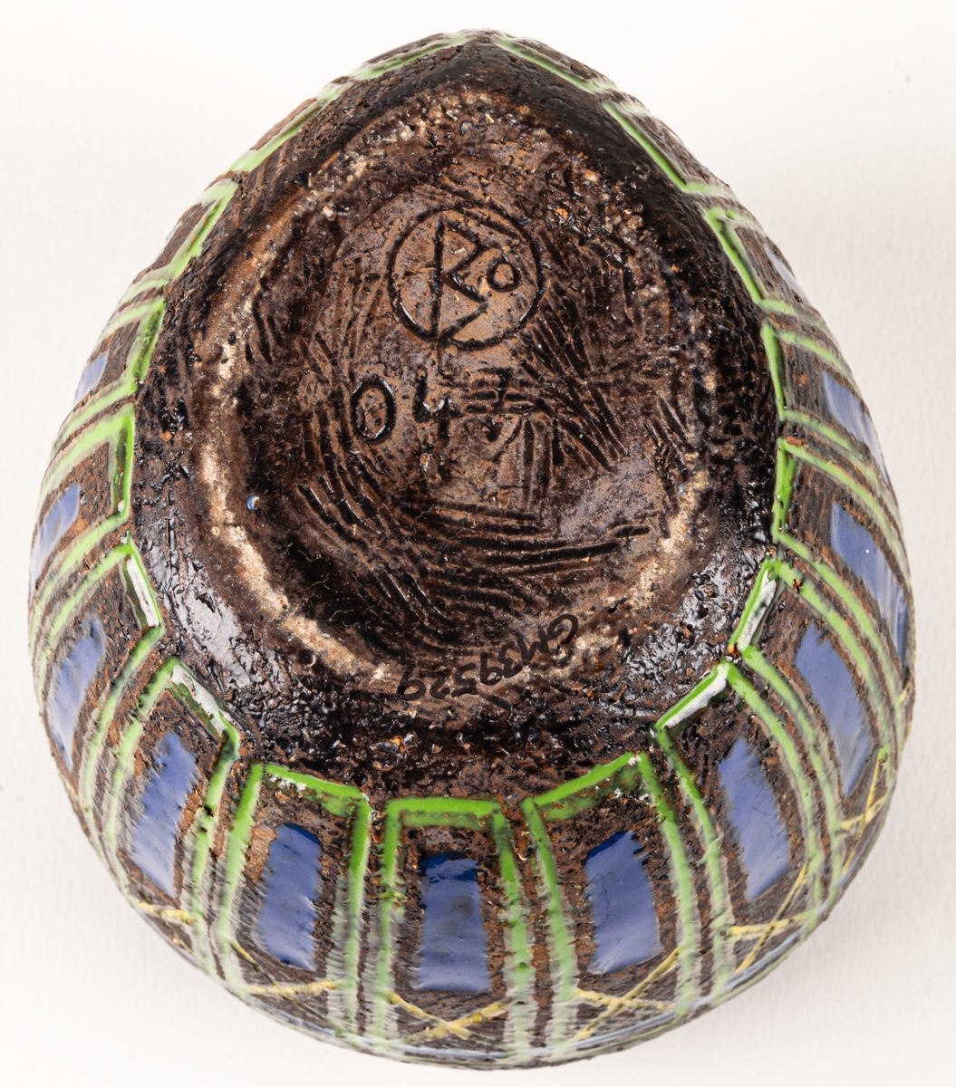 Bägare i svartbrun chamotte med blå, gula och gröna glasyrfyllda ristningar, formgiven av Berit Ternell 1953 hos Bo Fajans.