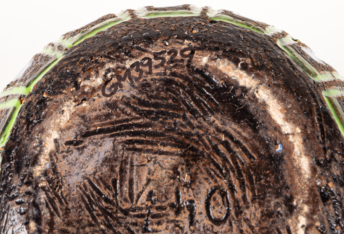 Bägare i svartbrun chamotte med blå, gula och gröna glasyrfyllda ristningar, formgiven av Berit Ternell 1953 hos Bo Fajans.