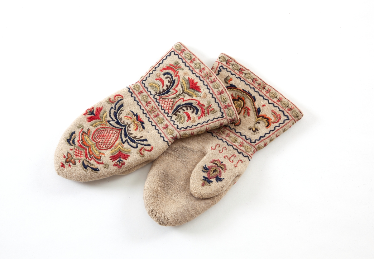 Hvite votter i nålebinding av ull med flerfaget broderi som dekor.