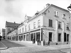 Storgatan 39 från sydost. Gården inköptes 1887 av köpmannen Axel Karlsson, som här drev en bred handel dock främst inriktad mot ekipering. Kort före bilden hade han låtit förändrat byggnadens fasad kraftigt, bland annat sattes skyltfönster i gatuplanet.