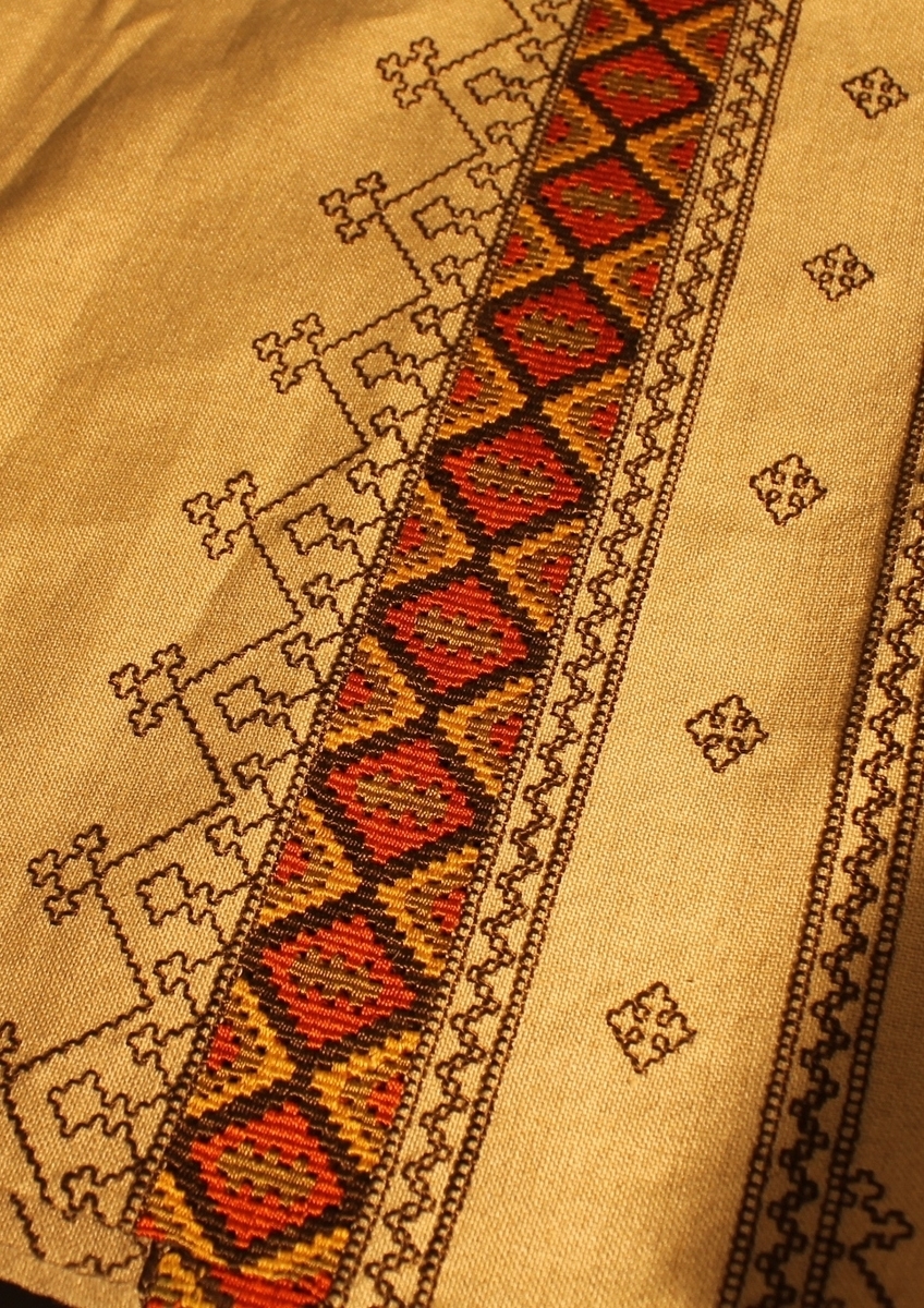 Brodert geometriske border. Flettet parti nede.