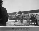 Folksamling vid ett militärt flygplan SK 1, FVM Albatros, i april 1927. Militärer och civila. Flygplanet märkt nummer 315X. Snömodd på marken.