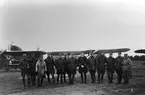 Gruppbild av flygofficerare uppställda framför flygplan på flygfältet på Malmen, slutet av 1920-talet. I mitten Einar Lundborg, till höger om honom Mauritz Hinnerson.