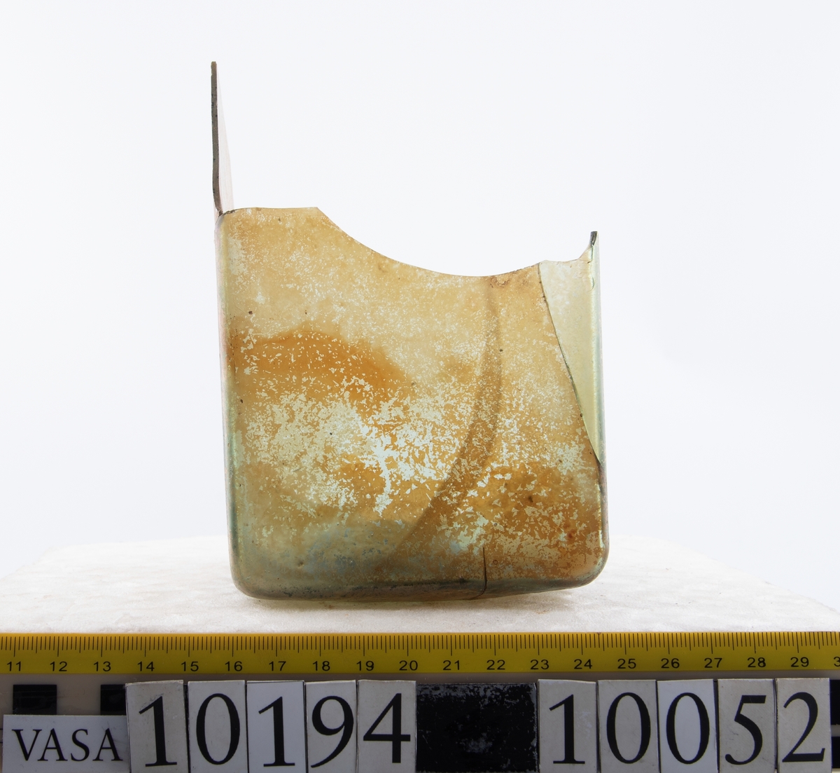 Botten samt fyra skärvor från fyrsidig flaska med stucken botten. På bottnens undersida finns ett puntelmärke. Glaset är grönfärgat och har en iriserande beläggning.

No damage. All pieces are a light green color and are from a case bottle.
10194a: has worn spot
10194c: Consists of two artifact numbers that have been glued together. Artifact has moderate scaling.