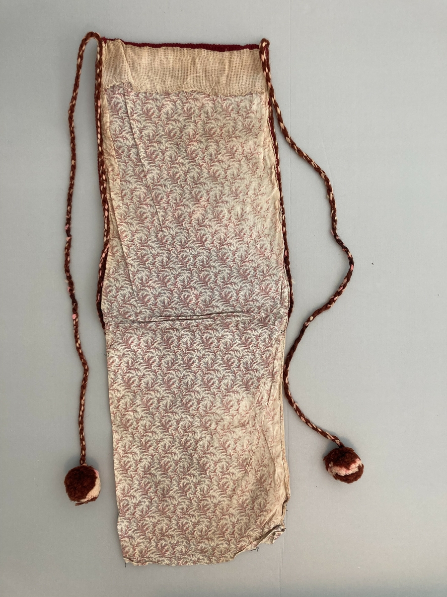 Brev-veske til oppbevaring av post? Sauma i mønstret stoff. På halve stoff-lengda er det sauma på ein brodera del. Dobbel korssting. 2 tvinna gån (garn) med duskar i endane.