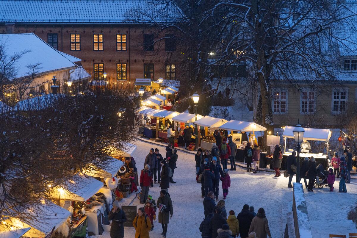 Markedsboder på Norsk Folkemuseums julemarked i skumringen fra 2021