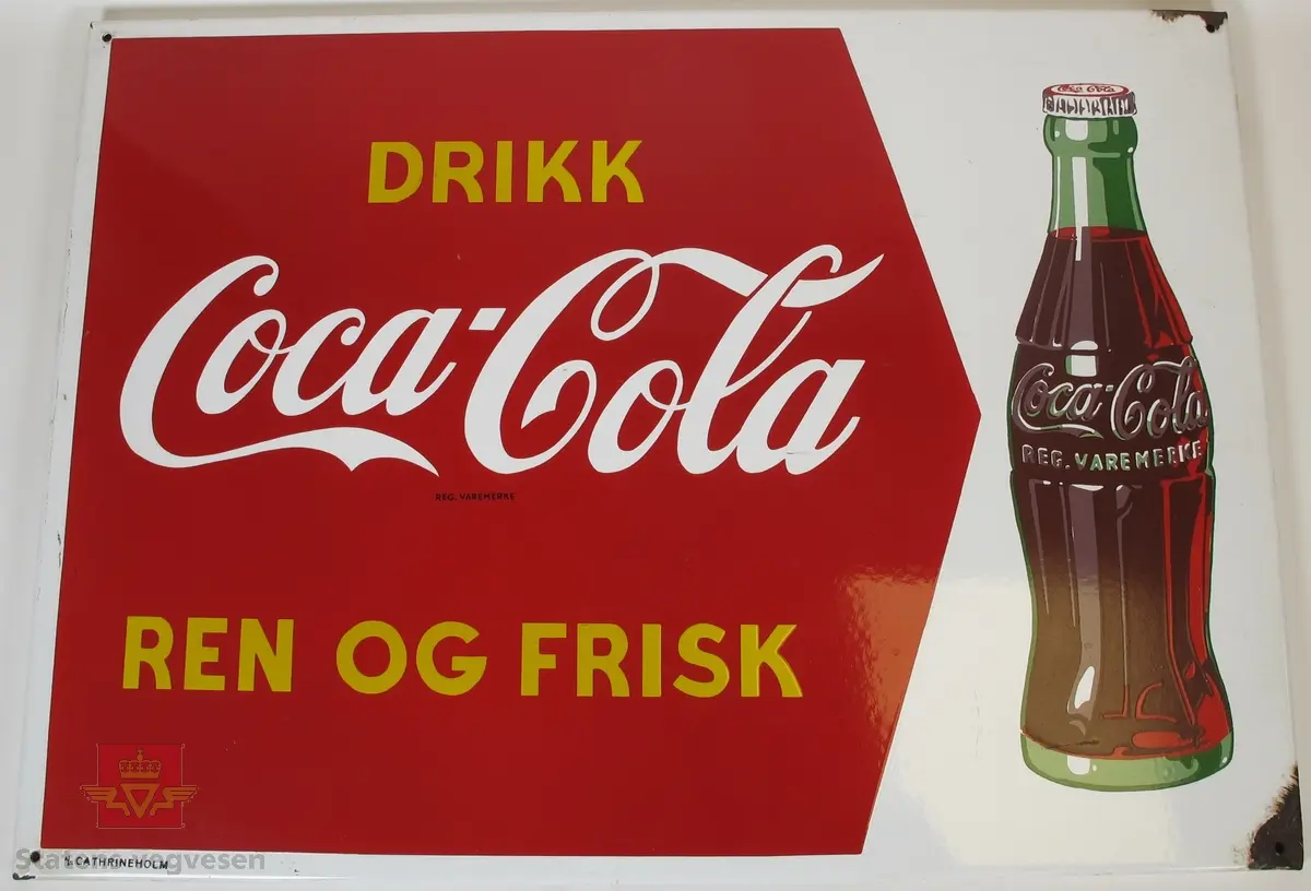 Hovedsakelig rødt og hvitt emaljeskilt laget av metall. Det er et skruehull i hvert hjørne og rust rundt to av disse.