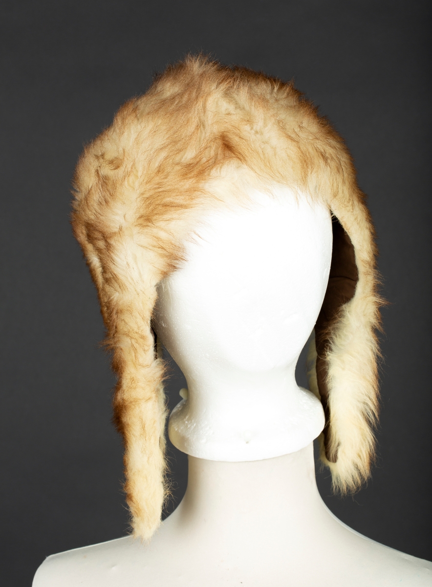 Hjelmelue i imitert pels. Knapping av sideklaffer under haken