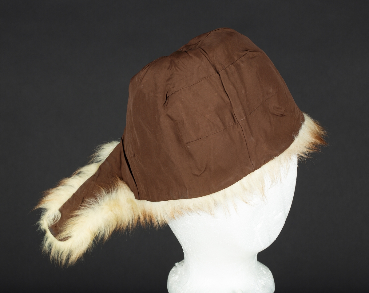 Hjelmelue i imitert pels. Knapping av sideklaffer under haken