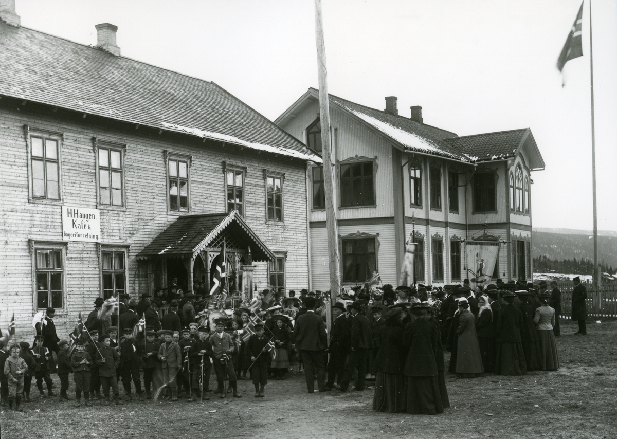 Folk med flagg og faner foran Arbeidern og Tingvang i Innbygda.