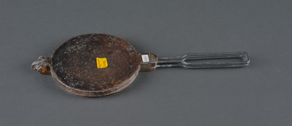 Lite krumkakejern for steining av krumkaker. 
Legges på plate e.l. 
Dekor på innsiden av stekeplatene.