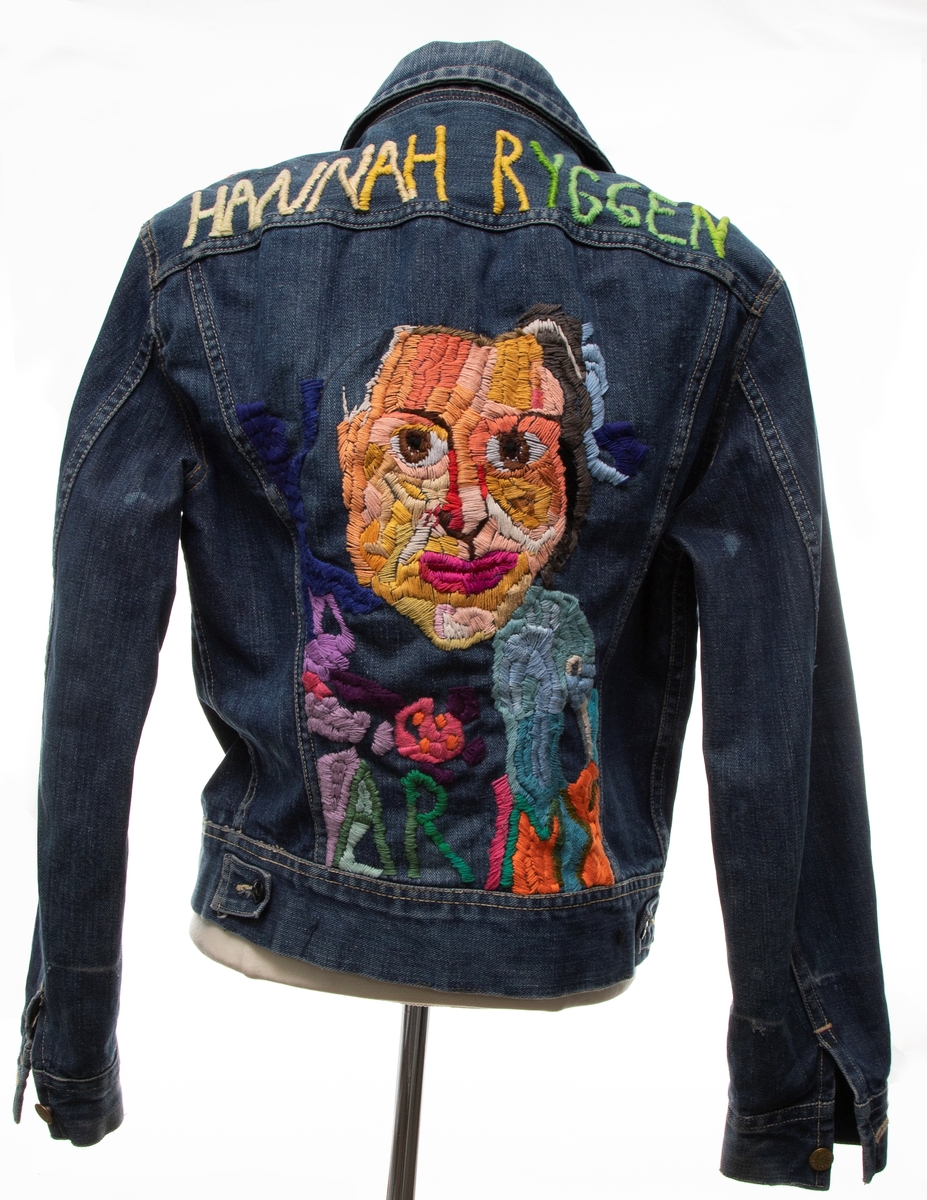 På en jeansjakke (av merket Lee) er et figurativt motiv brodert på ryggstykket. Motivet er et portrett av en annen kunstners selvportrett; det refererer til en detalj fra Hannah Ryggens billedteppe "Ja, vi elsker" (1950), der Ryggen har avbildet seg selv smilende med grågås og vevpinne i hånden. Med plattsøm er et utsnitt av dette portrett gjengitt med bomullstråd i mange og sterke farger, som bryter opp motivet i fasetter. Navnet "HANNAH RYGGEN" er brodert i gule og grønne toner på et øvre ryggstykke, mens "ARMY" inngår i hovedfeltet, under portrettet. Gåsehodet fra billedteppet er også inkludert. I tillegg omgir friere fargefelt, som delvis er inspirert av former og fargenyanser i billedveven, portrettet av Hannah Ryggen.