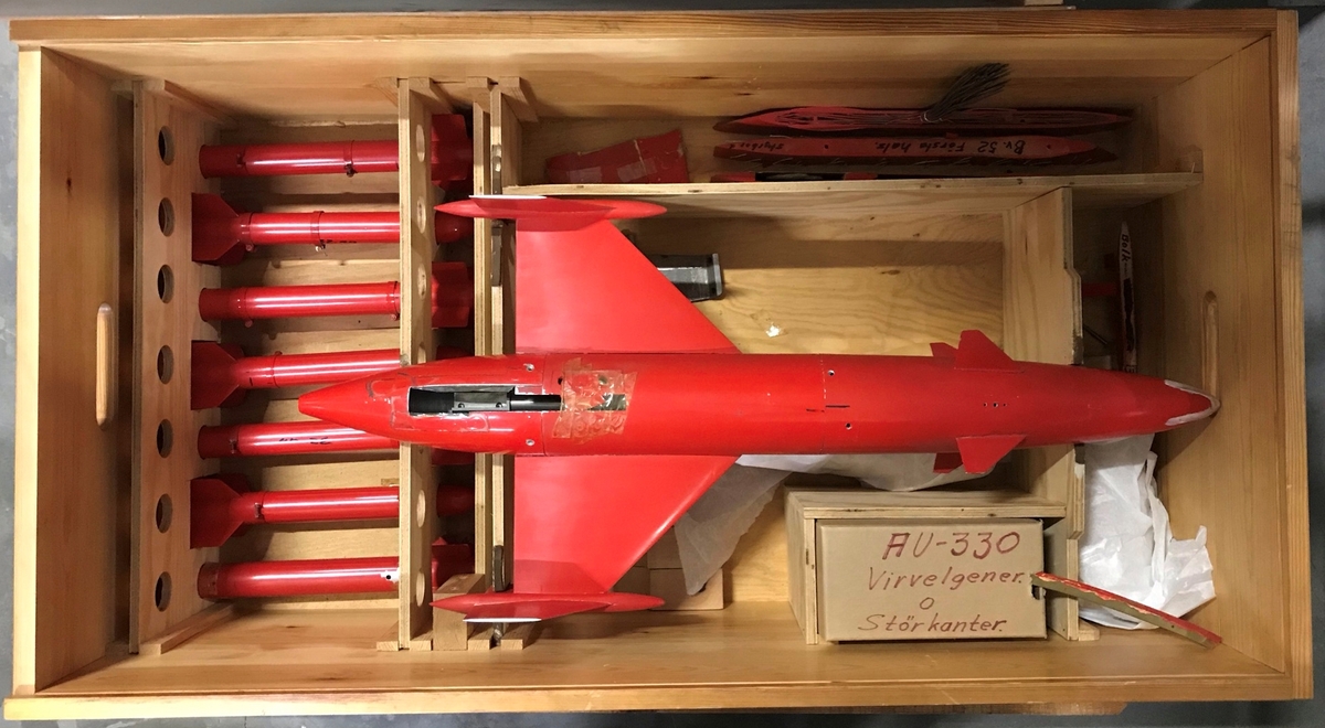 Låda med vindtunnelmodeller av robotar och raketer samt vapenbalkar. Möjligen försöksmodeller av Robot 04 eller Robot 321.