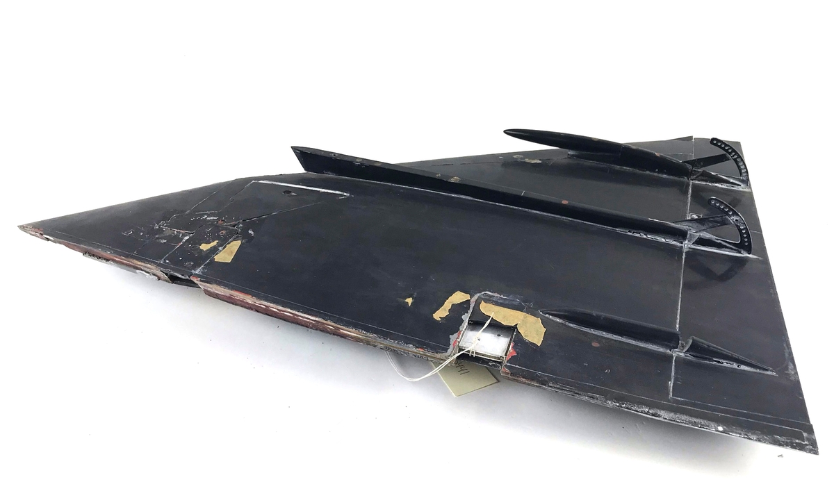 Vindtunnelmodell, vänster vinge till Saab 37 Viggen. Svartmålad, trä och metall.