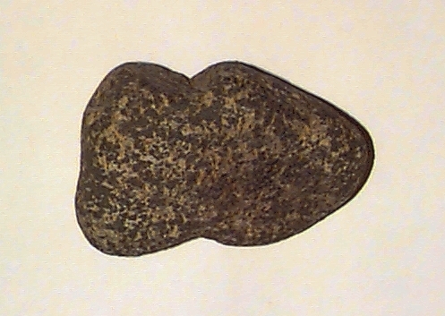 Sänkesten? Med två mittemot varandra (på styckets smalsidor) liggande inhak. Färg: grå och beige (spräcklig).