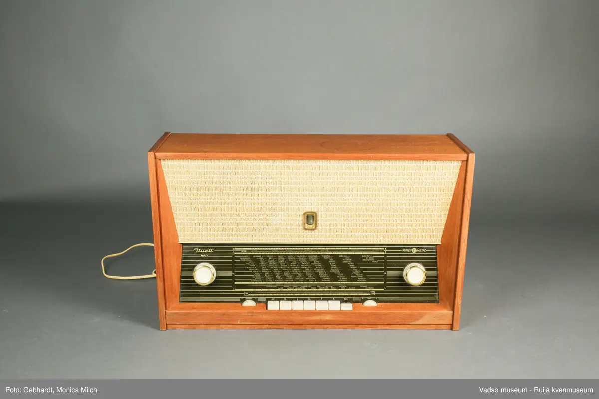 Stor treradio fra Radionette. Radioen har en glasskjerm på framsiden. På bakveggen, som kan tas av, er detaljene om radioen og bruken av den skrevet ned.