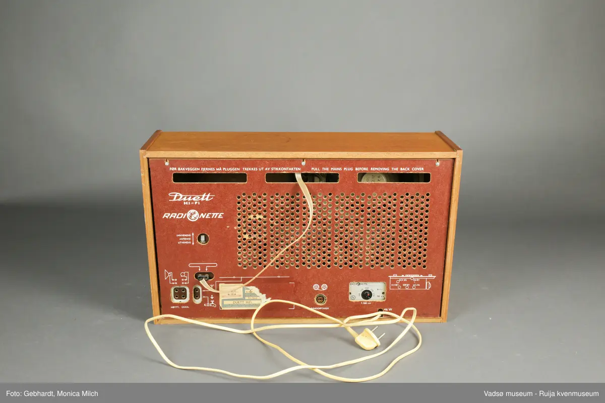Stor treradio fra Radionette. Radioen har en glasskjerm på framsiden. På bakveggen, som kan tas av, er detaljene om radioen og bruken av den skrevet ned.