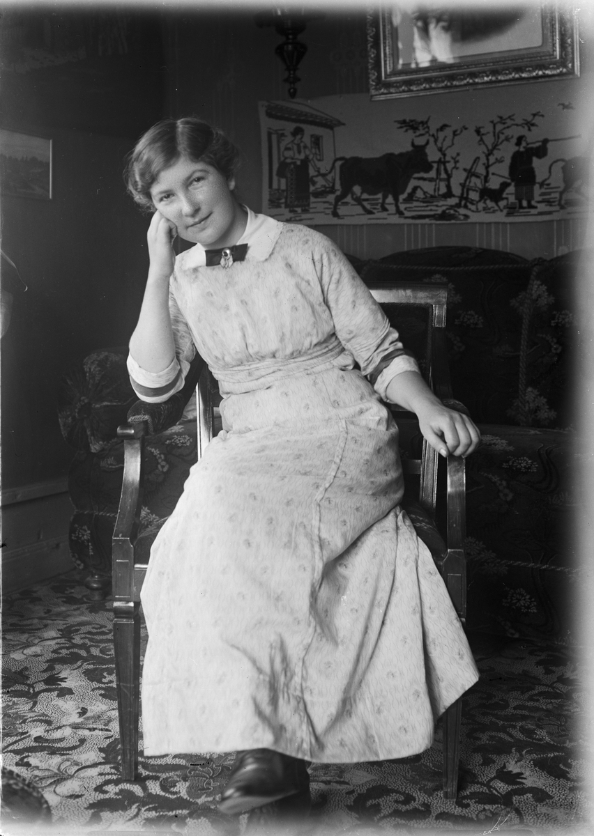 Sigrid sitter på stol i familjen Lauréns hem på Järnbrogatan 19, Uppsala