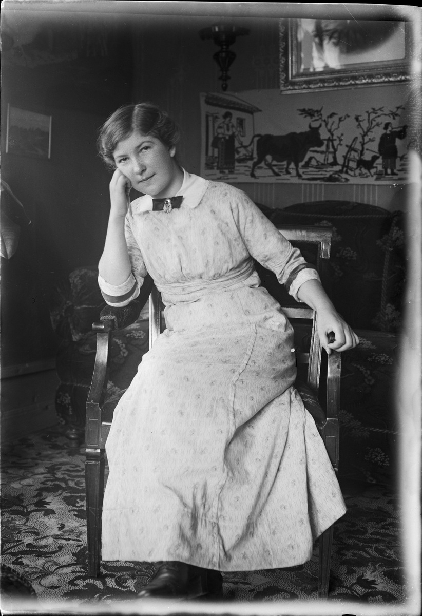 Sigrid sitter på stol i familjen Lauréns hem på Järnbrogatan 19, Uppsala